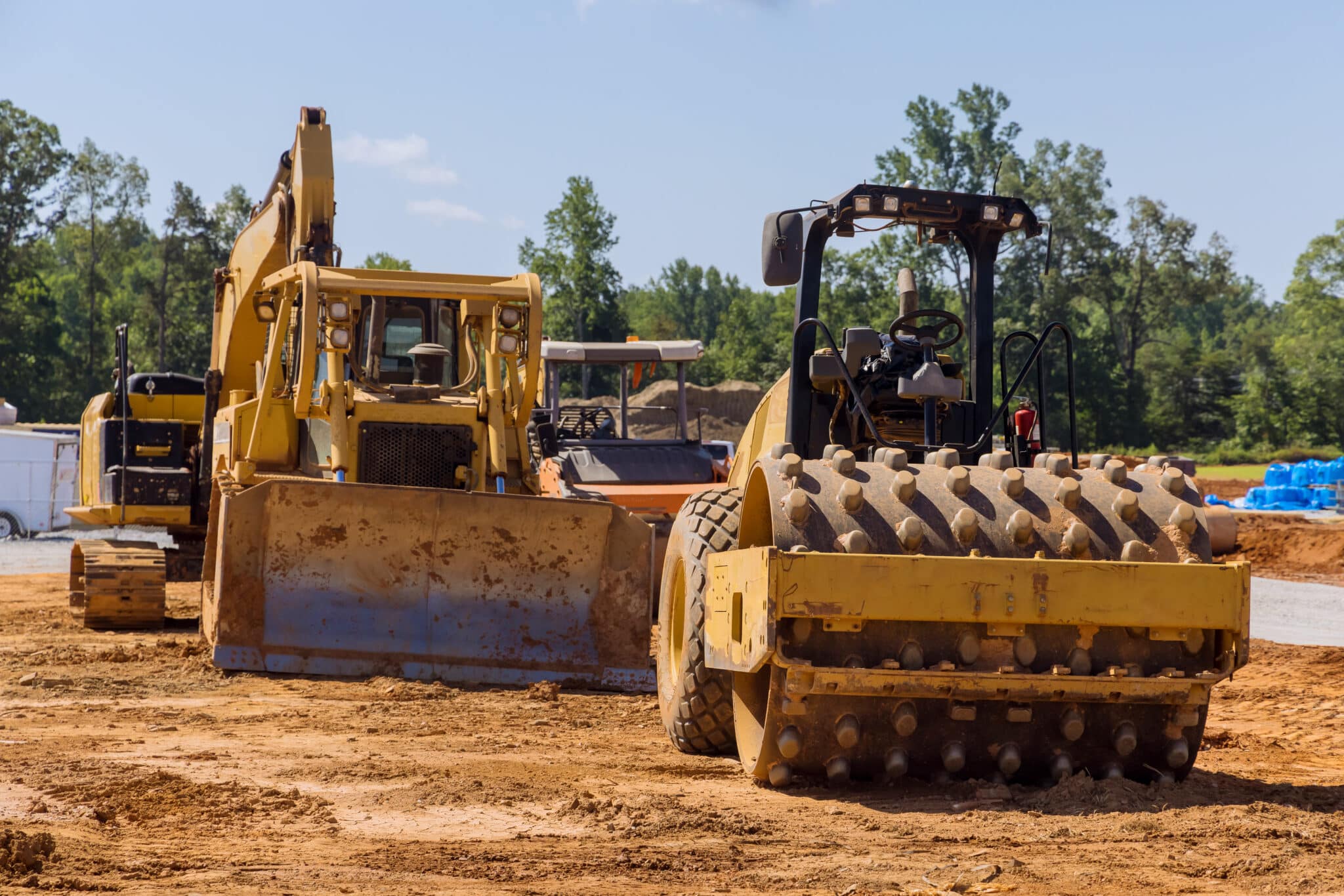 Tracteur et pelle hydraulique en activité sur chantier de terrassement et travaux publics