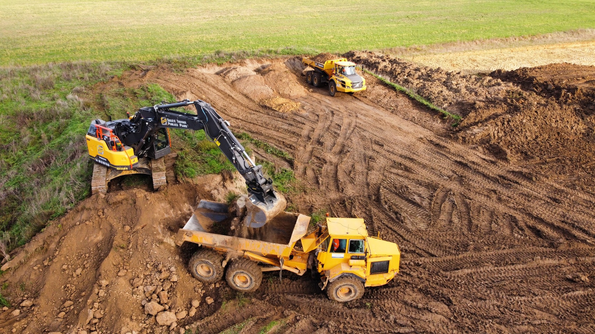 Chantier de terrassement avec pelle mécanique et tombereau transportant de la terre en Normandie