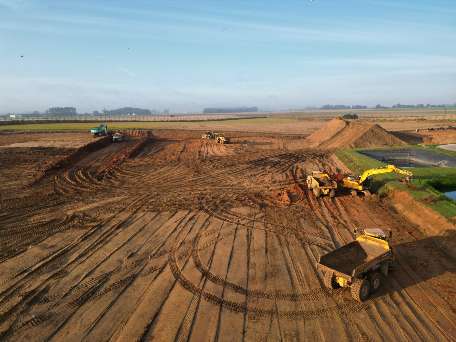 Terrassement en cours avec engins de chantier sur un grand terrain agricole
